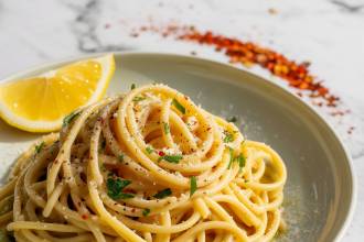 A bowl of lemon garlic pasta garnished with parsley and lemon zest