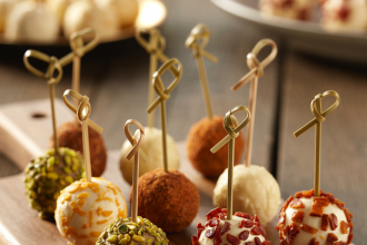 A plate of colorful assorted mini cheese balls decorated with herbs and nuts