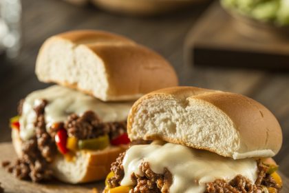 A delicious philly cheese steak sloppy joes sandwich loaded with melted cheese, ground beef, and sautéed peppers on a toasted bun